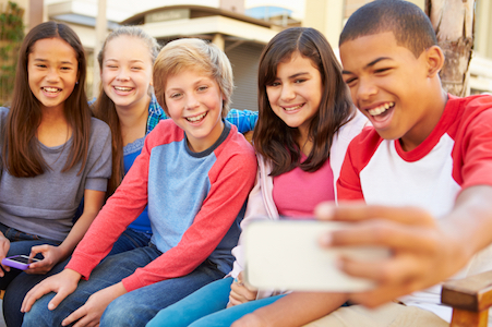 Group of children who get pediatric dentistry services from Santa Teresa Dental Center pose for a selfie. 