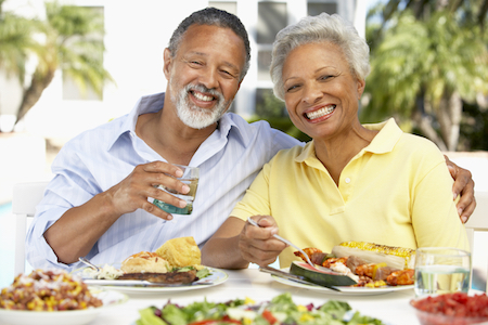 Older couple at brunch smile confident they can eat anything with a dental bridge from Santa Teresa Dental Center in San Jose, CA.